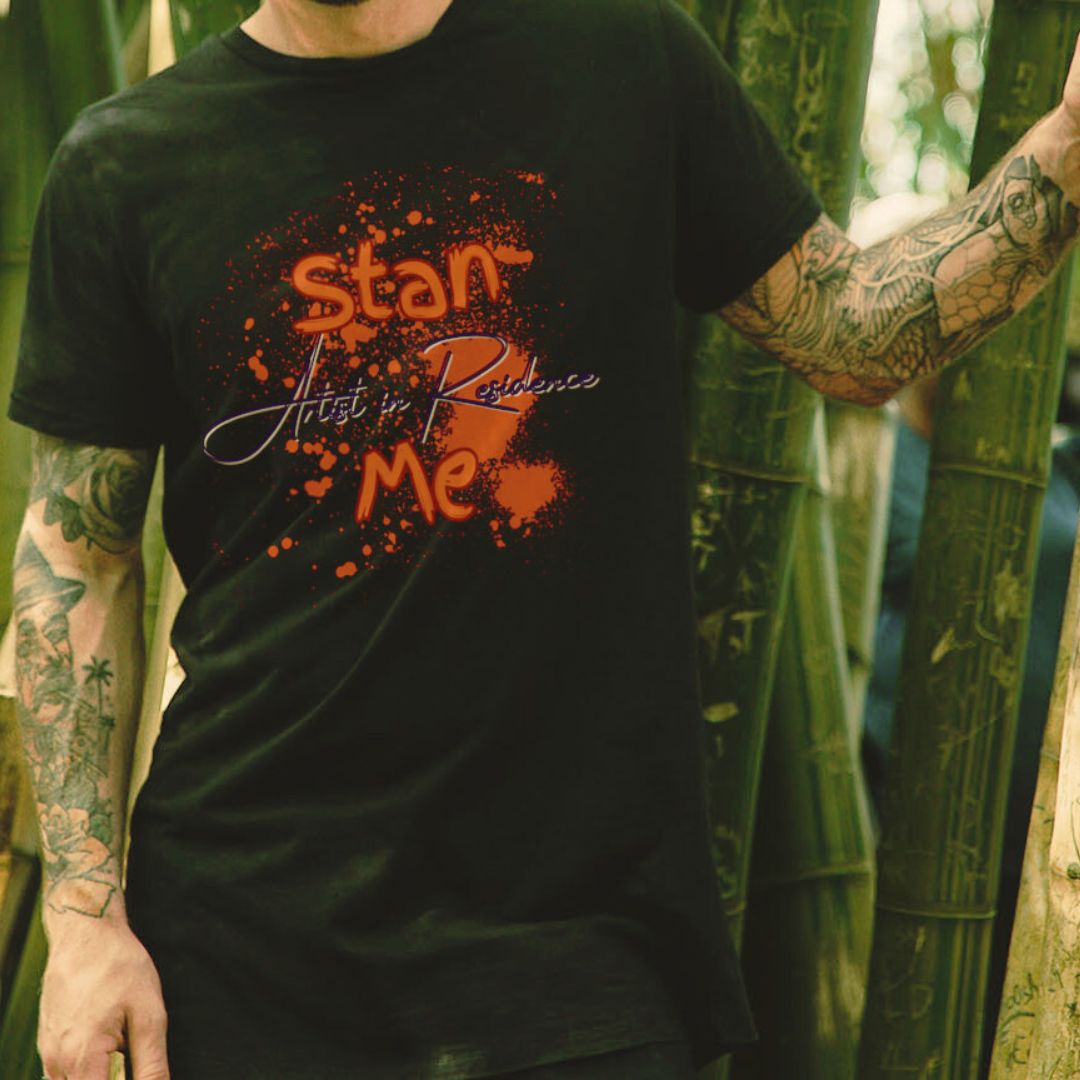 “Stan Me, Artist in Residence” tees featuring paint splatter designs, blending artistic creativity with stan culture. Available in 8 unique styles. Perfect for artists looking to attract fans and gigs.