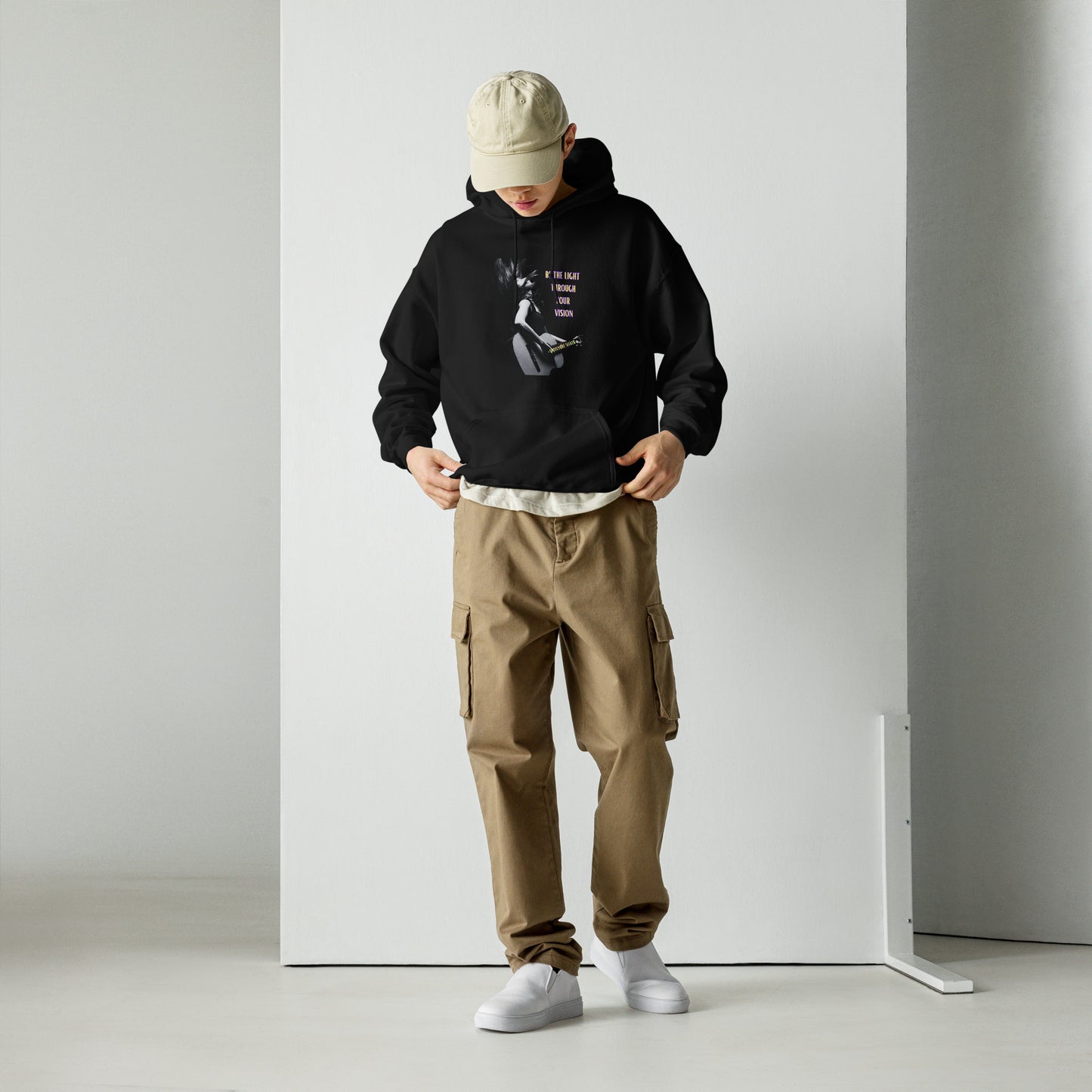 A stylish black and white Heavyweight Be the Light Unisex Hoodie displayed against a backdrop of creativity. The bold graphics symbolize authenticity, inviting artists to embrace their vision and be the light for their audience.